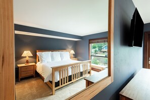Ein Schlafzimmer mit einem Bett, zwei Nachttischen, einer Fensterbank und einer Holzbank.