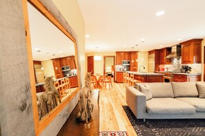 A spacious living area with a large mirror, wooden flooring, and a grey sofa. - Historic Old Town 2BR/2BA condo with mountain views. (Park City)