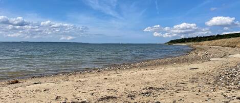 A beach with a rocky shoreline and calm water.