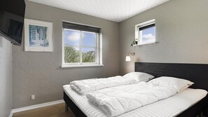 A bedroom with two beds, a window, a wall-mounted shelf, and a framed picture. - VillaVilla 974 - Hvide Sande, Vestjylland (Hvide Sande)