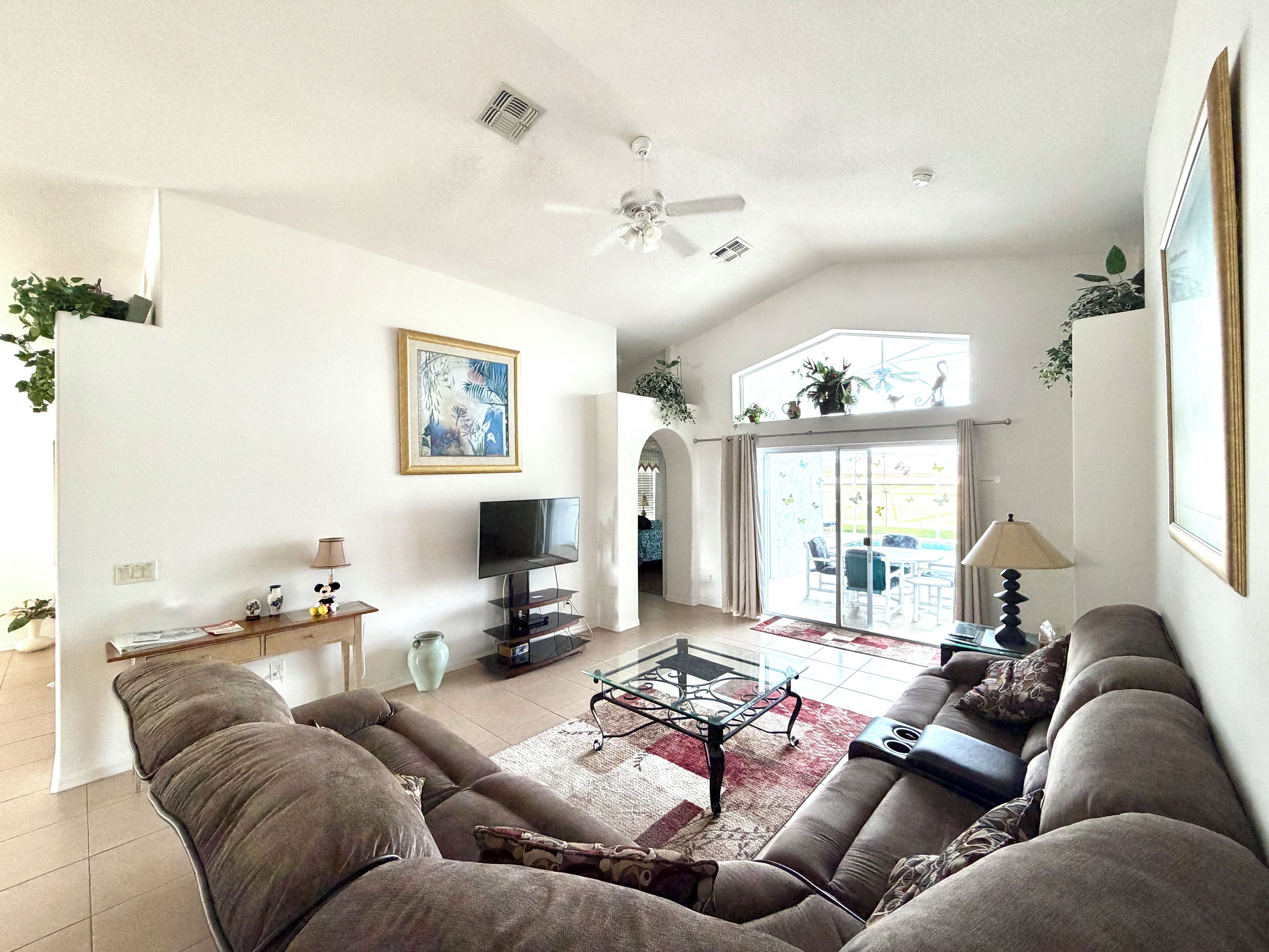 A spacious living room with a sofa set, a television, and a coffee table.