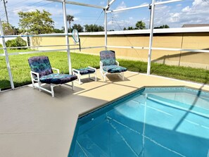 Ein Poolbereich mit zwei Liegestühlen.
