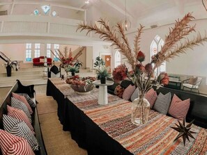 A spacious interior with a long dining table, multiple seating arrangements, and decorative plants. - White Bohemian,2 houses, 9000 sq ft Games, Hot Tub Events - sleeps 34 (Atlanta)