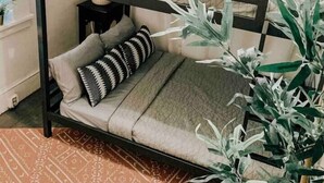 Ein Etagenbett mit zwei Schlafstellen, jeweils mit Kissen und Decke.