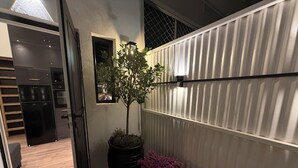Een moderne keuken met een zwarte koelkast, een bloempot en een rieten mand met paarse bloemen.
