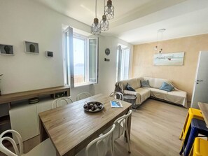Ein stilvoller Wohnraum mit Essbereich, einer Couch und Meerblick.