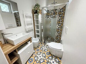 Ein Badezimmer mit weißem Waschbecken, WC und Dusche.