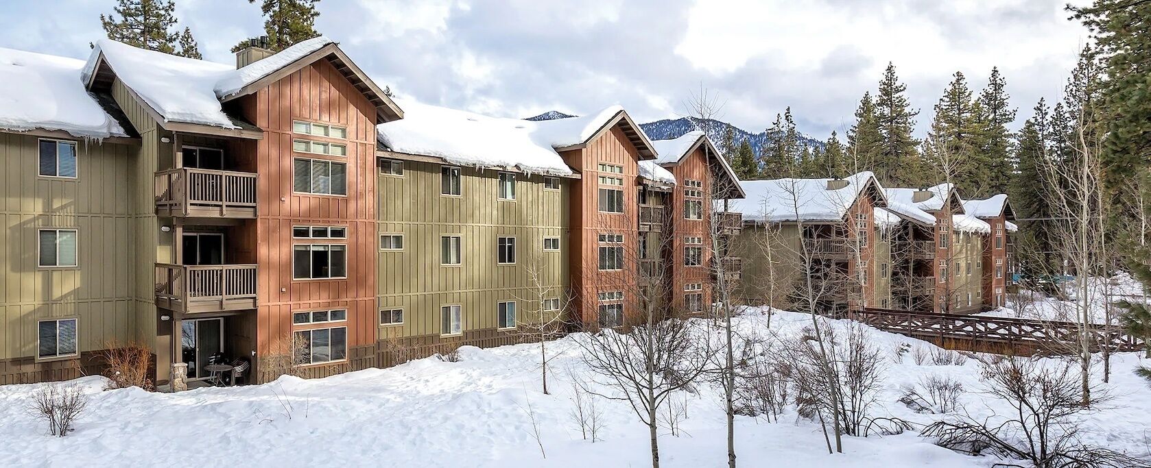 Un hotel de varios pisos con balcones y un paisaje nevado.