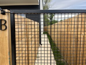 Ein begrenzter Eingangsbereich mit Holzparkanlage und einem Betonweg, der zu einem Gebäude führt.