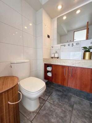 Ein modernes Badezimmer mit Toilette, Waschtisch und Spiegel.