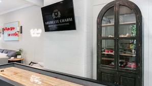 Et billardbord i et rum med et skilt for 'Absolute Charms Luxury Accommodations' og et stort buet glaskab.