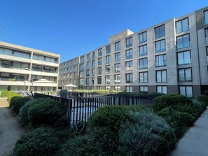 A modern building with multiple floors, a courtyard with a fence, and greenery. - Quiet Studio, Best Price, and Near the Metro (Santiago)