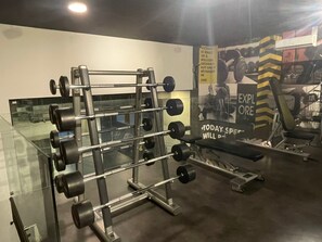 Ein Fitnessstudio mit Squat-Stange, Langhanteln und Gewichtsplatten.