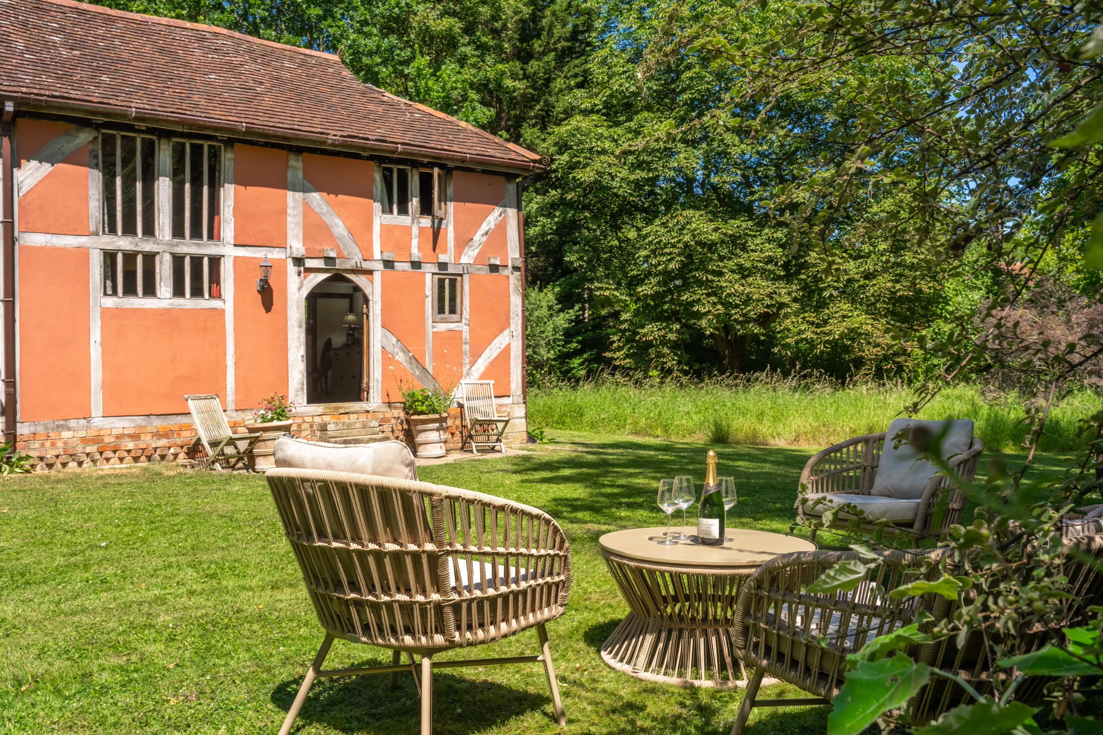 Un bâtiment traditionnel avec un toit en tuiles, une base en briques et une grande porte d’entrée en arc de cercle.