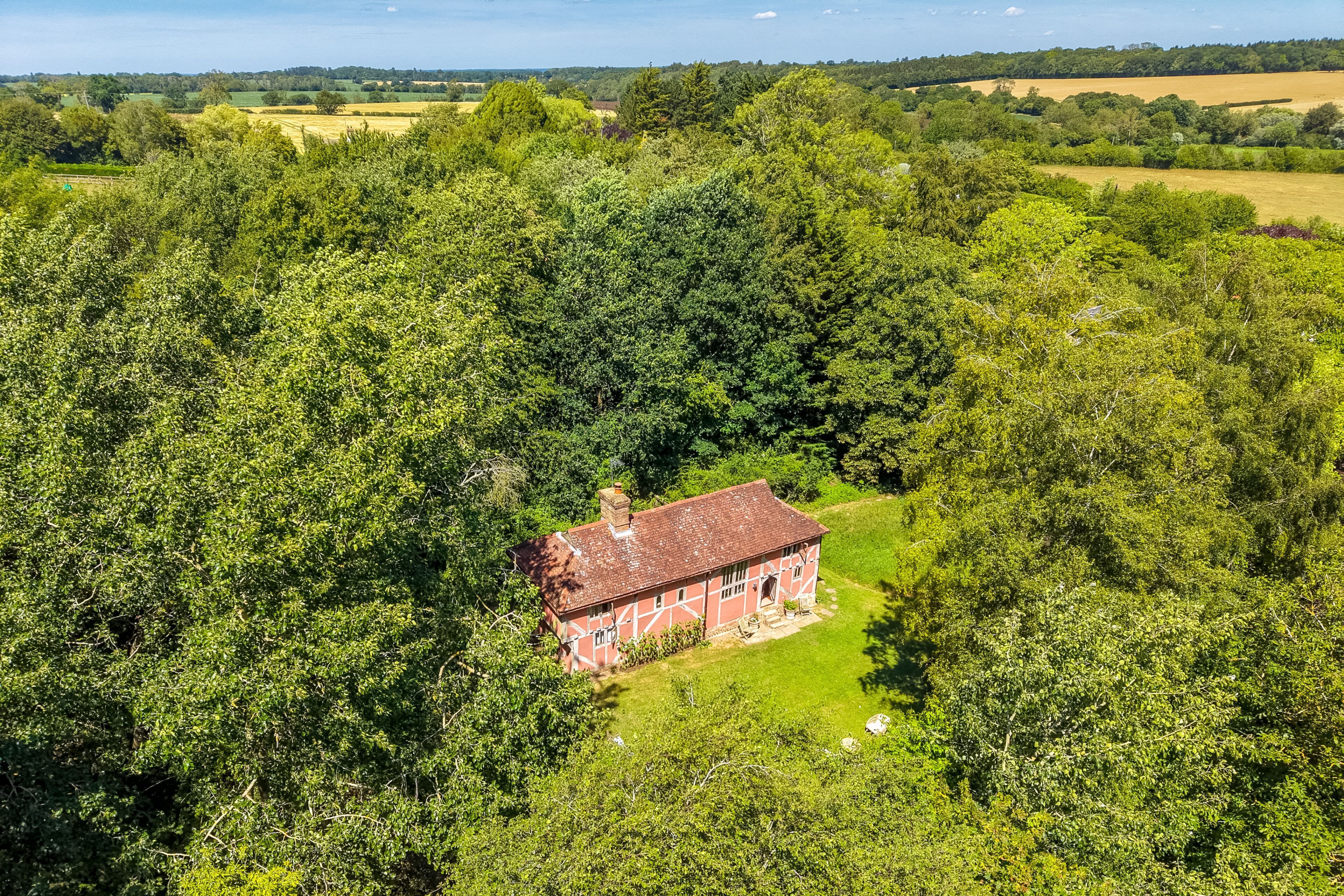 A red building surrounded by dense green trees.