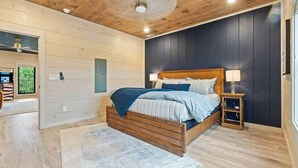 Un dormitorio con cama de madera, una mesita de noche y un ventilador de techo.