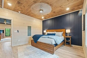 Ein Schlafzimmer mit einem Holzbett, einem Nachttisch und einem Deckenventilator.