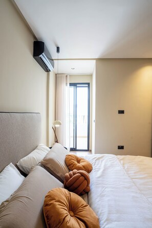 Habitación de hotel con cama, almohadas, lámpara y ventana.