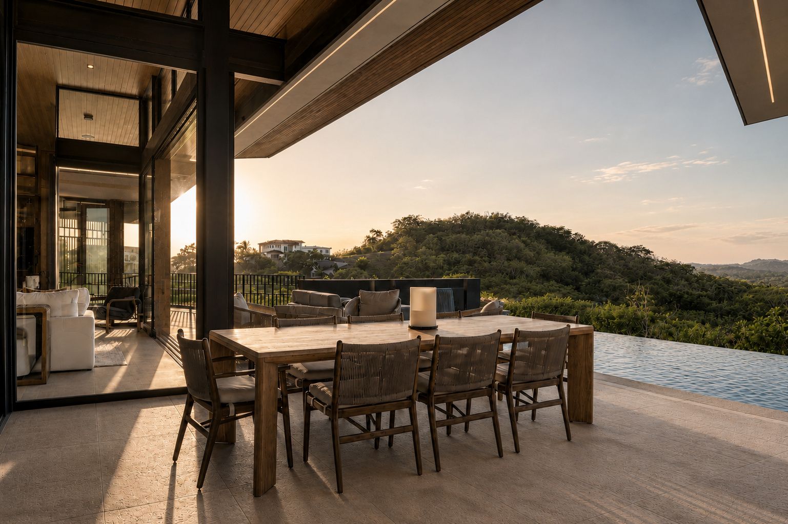 A dining area with a table and chairs, overlooking a pool and a scenic landscape.