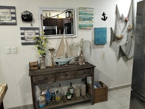 Eine Küche mit einem Holztisch, auf dem Flaschen und ein Modell eines Segelbootes stehen.