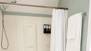 A bathroom with a shower, toilet, and bathtub.