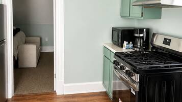 A kitchen with a stove, microwave, and cabinets.