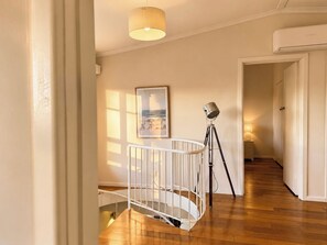 Ein Zimmer mit einem weißen Babybett, einer Stehlampe und einem gerahmten Bild an der Wand.