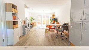 Eine moderne Küche mit Essbereich, Holzschränken und einem großen Fenster.