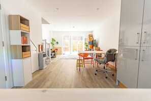 Eine moderne Küche mit Essbereich, Holzschränken und einem großen Fenster.