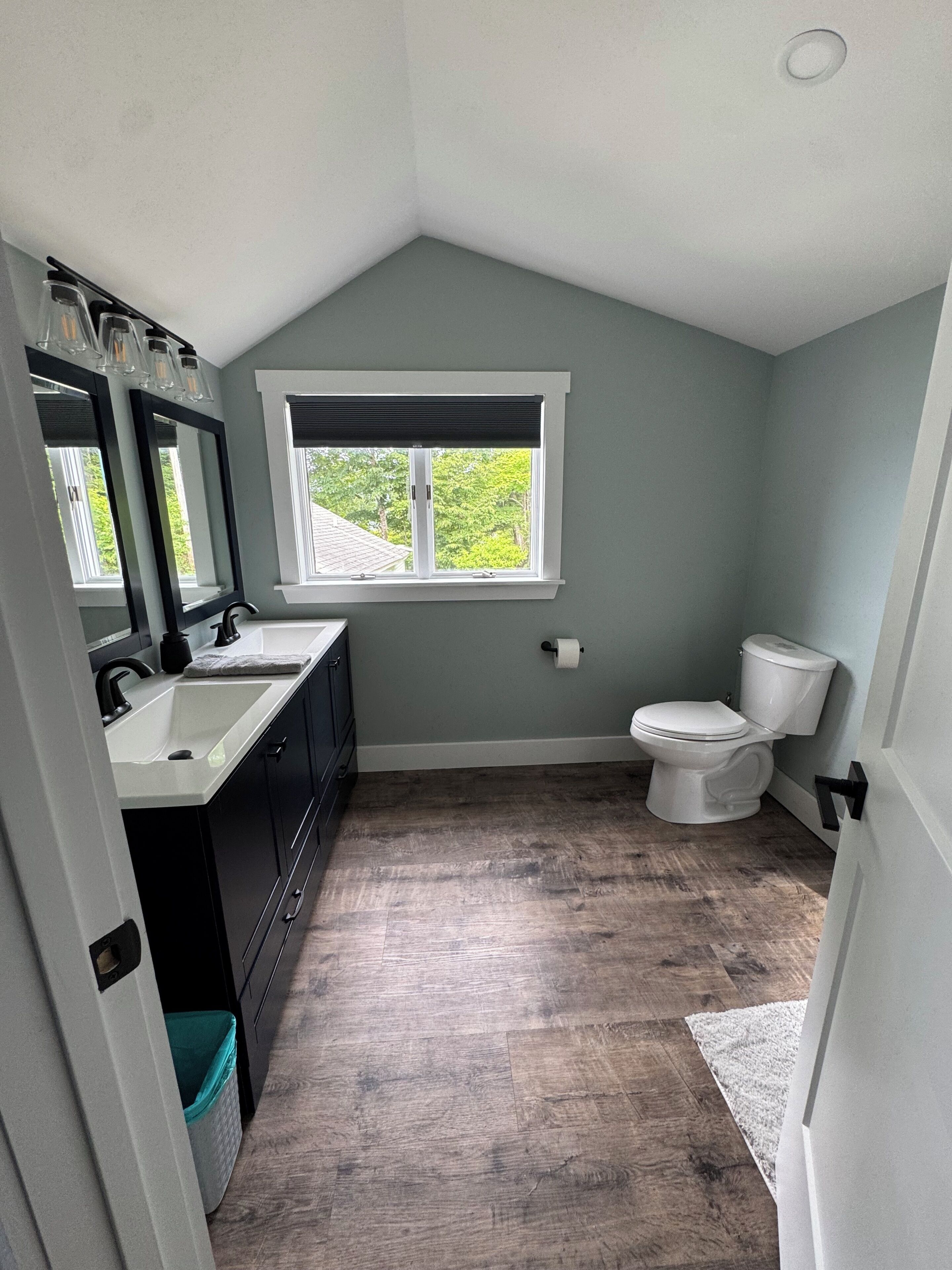 A bathroom with a window, a toilet, and a sink.