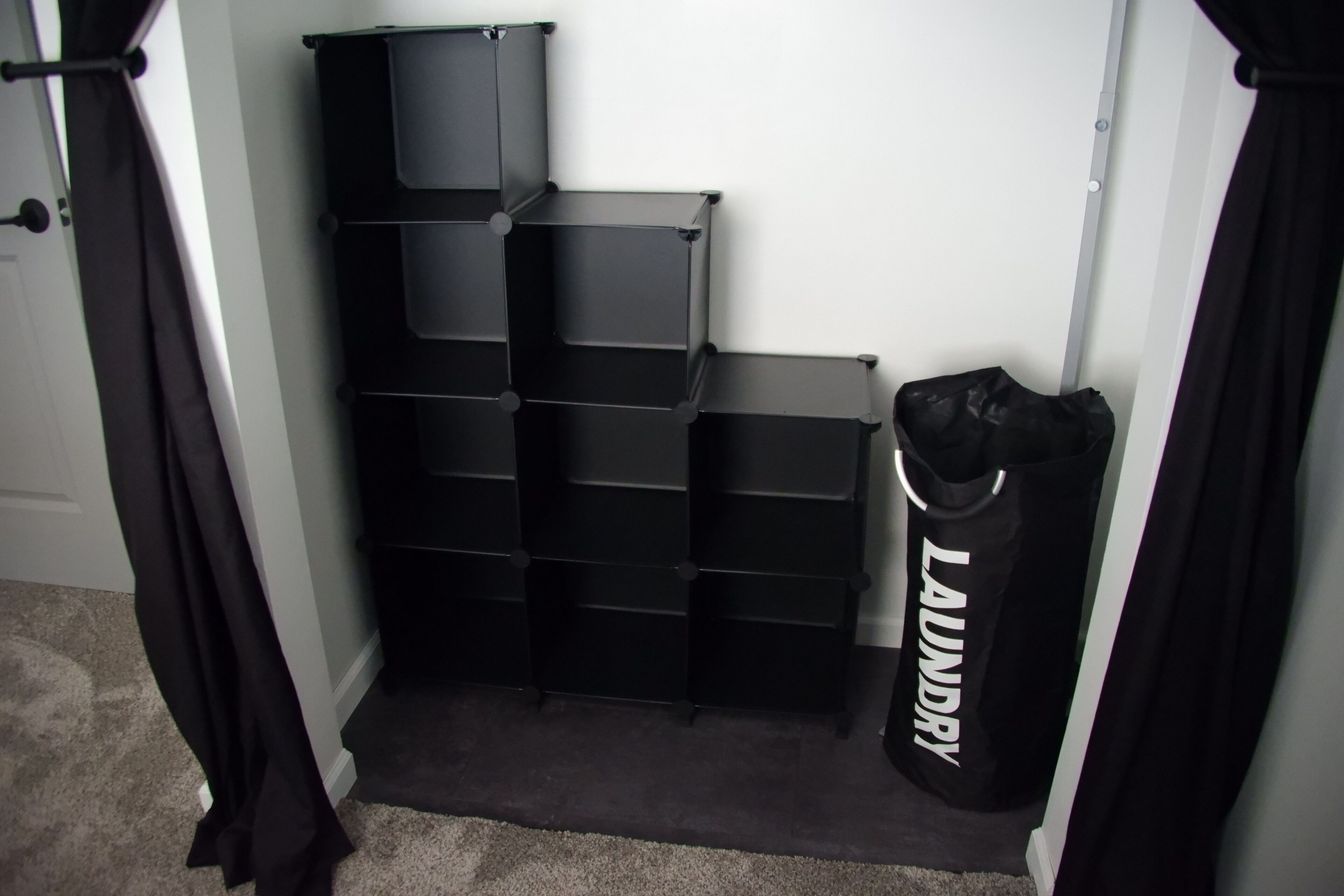 Un espace de rangement doté de plusieurs étagères et d’un sac à ordures.