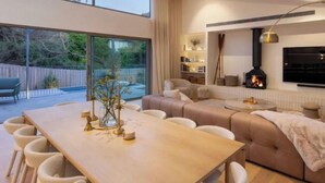 A modern living room with a sofa, a dining table, and a fireplace. - Ms Dana Bridgewater - Blairgorwie (Blairgowrie)