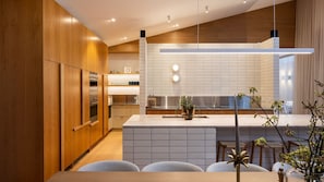 A modern kitchen with wooden cabinets, a stainless steel range, and a white tiled backsplash. - Ms Dana Bridgewater with heated magnesium pool (Blairgowrie)