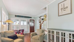Una sala acogedora con dos sillones, una mesa de madera y una estantería.