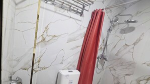 A bathroom with a toilet, shower, and a hand dryer. - Samarkand City Center Hotel (Samarkand)