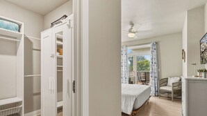 A bedroom with a bed, a chair, a desk, and a wardrobe.