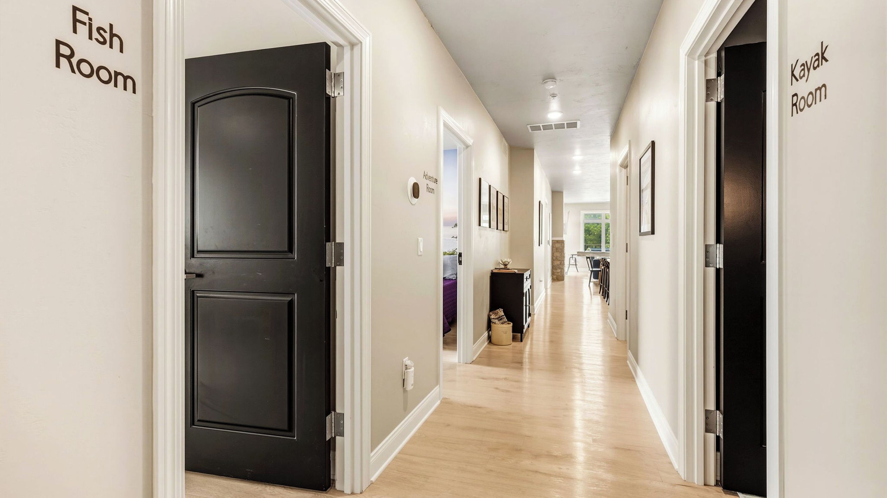 A hotel corridor with black doors labeled 'Fish Room' and 'Kayak Room'.