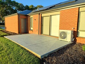 A building with a brick exterior, a concrete entrance, and an air conditioning unit.