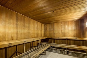 Eine Sauna mit Holzbänken und schrägverdeckter Decke.