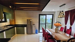 Una cucina moderna con zona pranzo, che include un tavolo spazioso e sedie, un frigorifero e vista attraverso la porta in vetro.