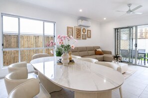 A modern living room with a marble table, beige sofa, and a large window. - The Willow House | Modern Family Retreat (Park Ridge)