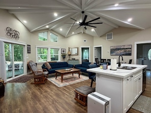 A spacious living area with a large sofa, a dining table, and a kitchen island.