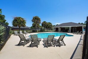 A swimming pool with lounge chairs and a covered seating area. - Coastal Orange Beach Retreat | Minutes to the Beach, The Wharf & Family Fun (Orange Beach)