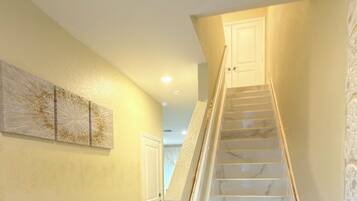 A staircase with marble steps and a handrail, leading to a door at the top.