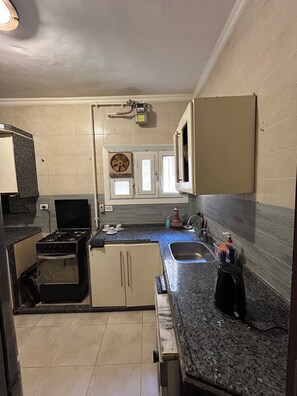 A compact kitchen with a stove, sink, and cabinets. - Luxury 3 bedroom Apartment in Rehab October City (Giza Governorate)