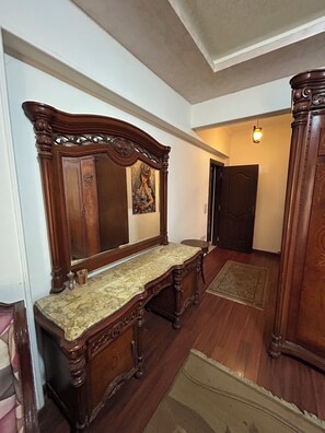 A room with a wooden vanity, a mirror, a door, and a light fixture. - Luxury 3 bedroom Apartment in Rehab October City (Giza Governorate)