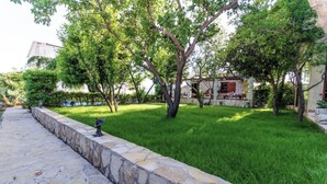 A stone pathway leading to a grassy area with trees and a stone building. - A 1  apt w shared pool and balcony, near the beach (Seget Vranjica)