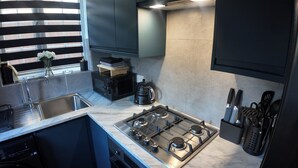 A modern kitchen with a built-in dishwasher, a gas stove, and a coffee maker. - Emerald Garden Suite - Wifi,Parking,Garden,Sleep 2 (London)