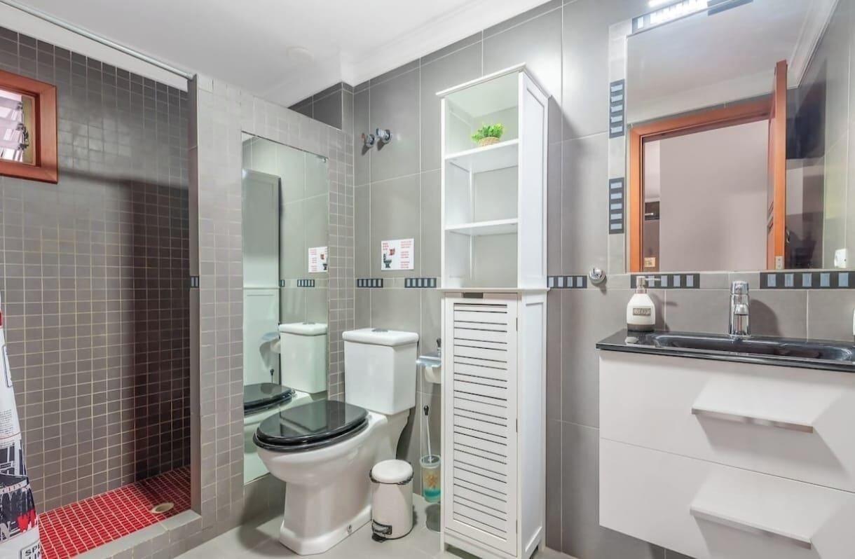 A bathroom with a toilet, bidet, and a sink with a mirror above it.