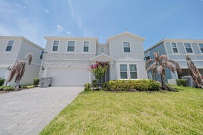 A two-story residential building with a garage, a paved driveway, and a well-maintained lawn. - Go!#37 - WINDSOR ISLAND (Davenport)